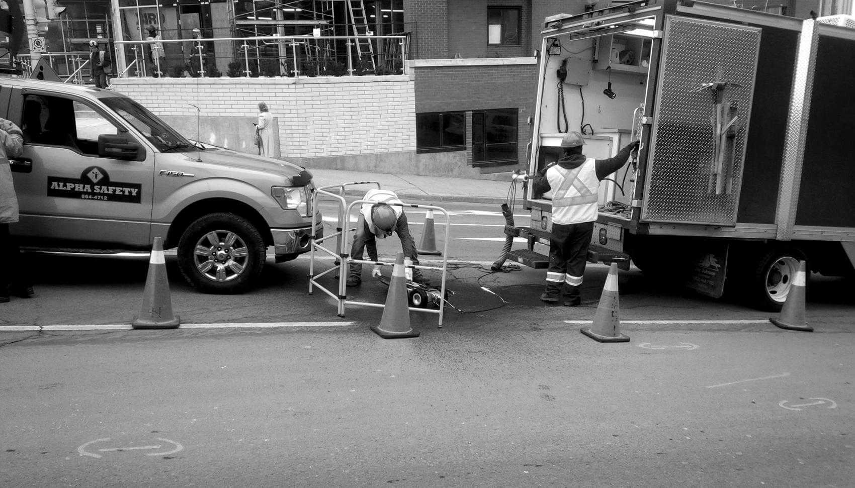 Workers and trucks getting ready for work on a manhols