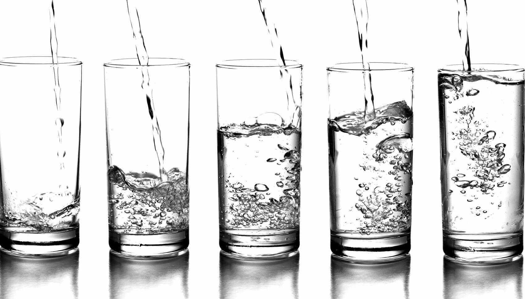 Glasses filled or being filled with water