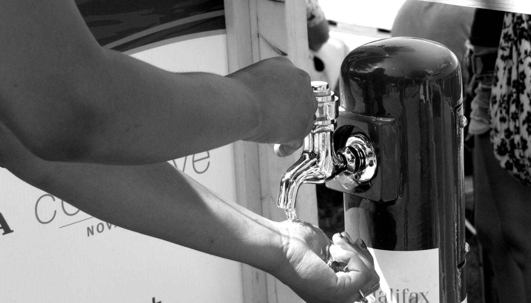 a portable Halifax Water tap being used to wash hands