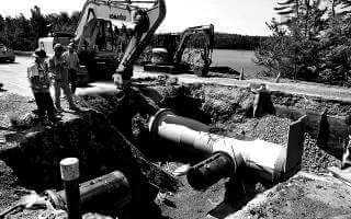 Crew standing near pipe